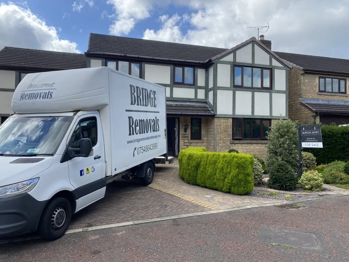 Bridge Removals van on the driveway of a mock-Tudor house with topiary bushes in Waterfoot Bridge Removals van on the driveway of a mock-Tudor house with topiary bushes in Waterfoot
