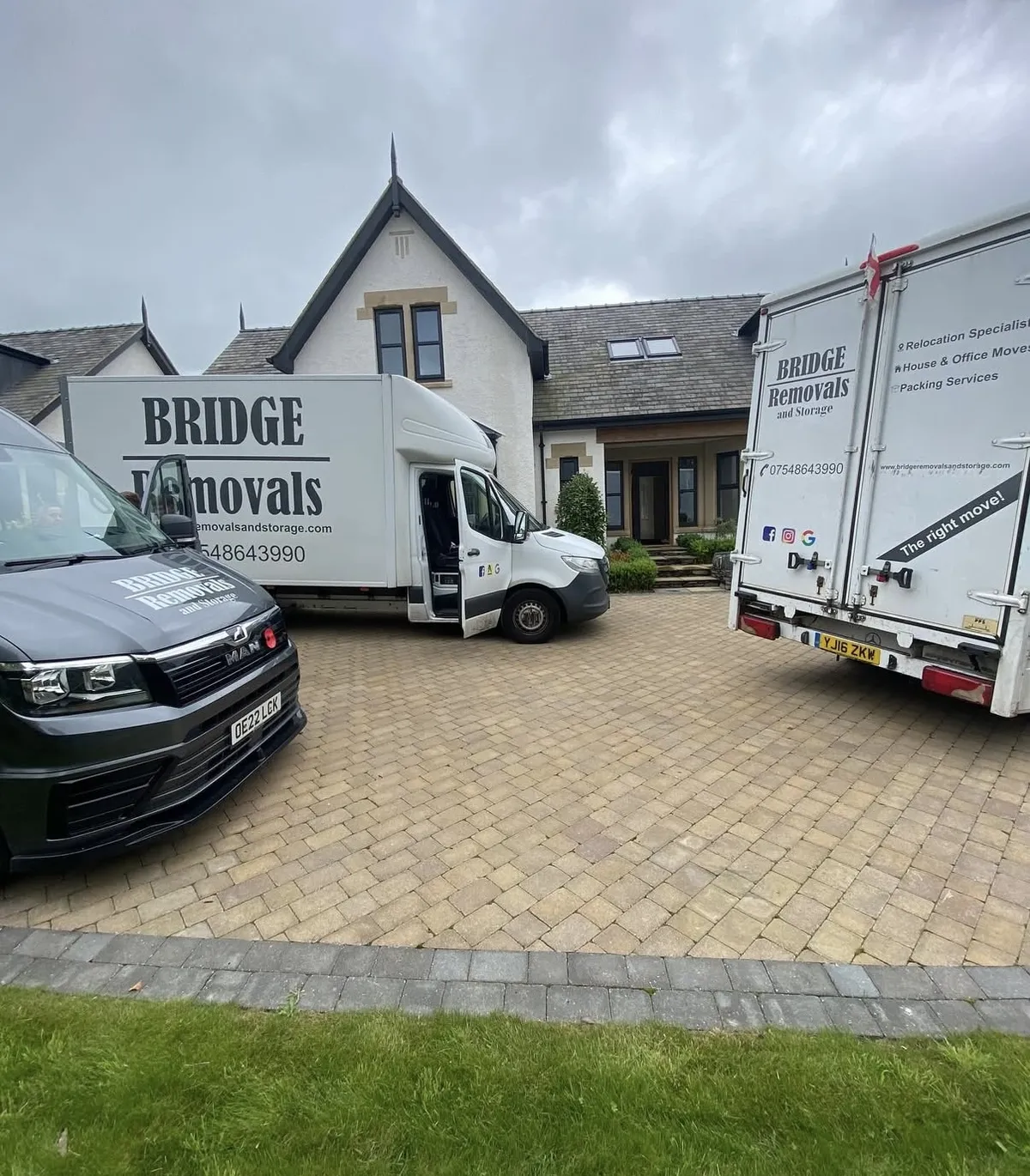 Three Bridge Removals vans on a house move at a large white detached house Three Bridge Removals vans on a house move at a large white detached house